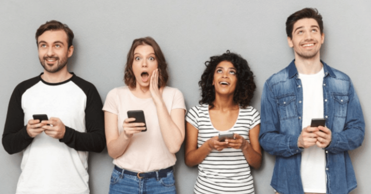 Four friends holding cellphones and smiling