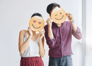 Man and women holding emojis