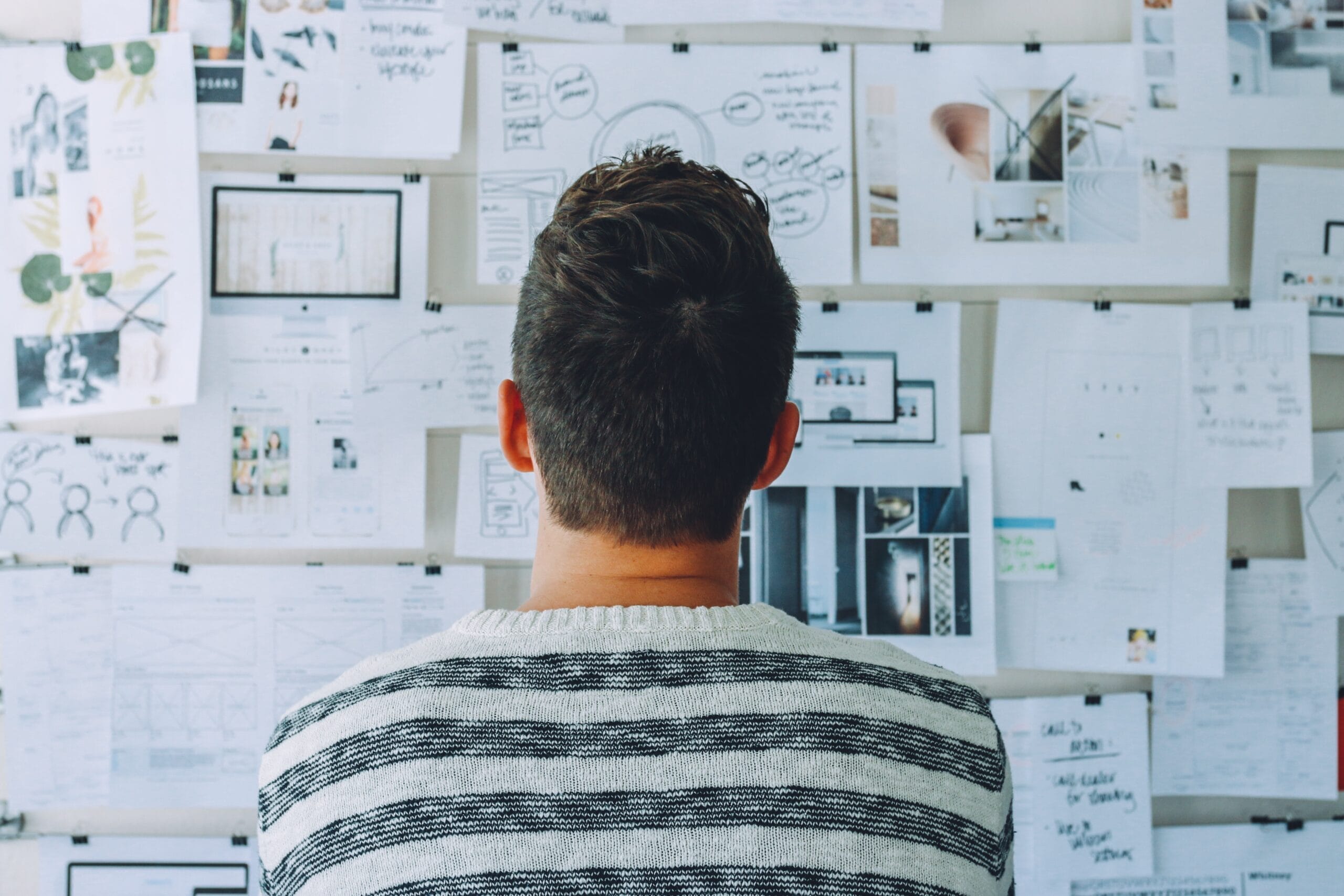 Man staring at a bulletin board full of marketing ideas